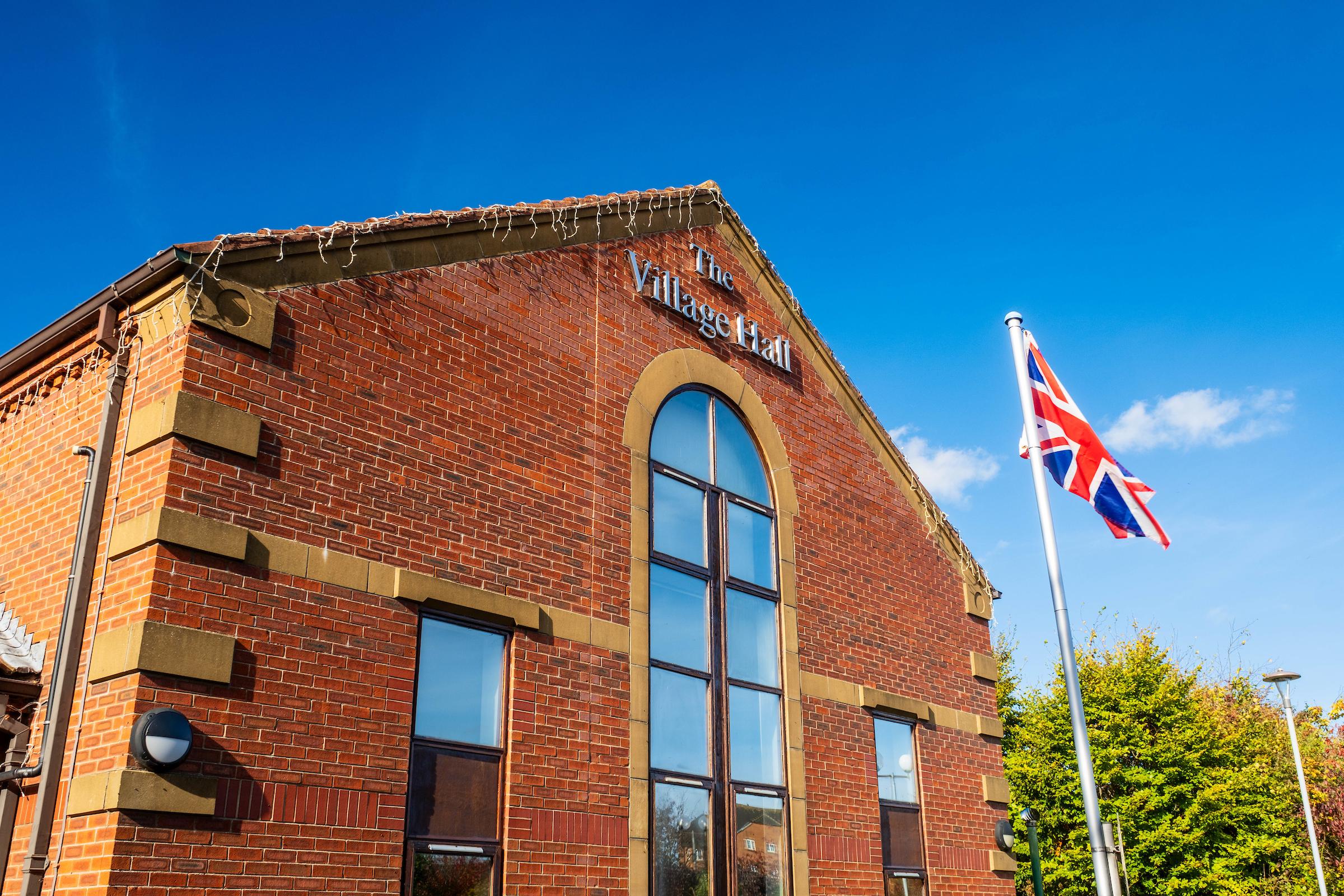 A photograph of the outside of Victoria Dock community centre showing a Union Jack flag flying