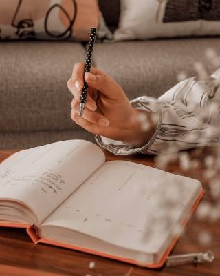 A decorative image of a pen and a planner