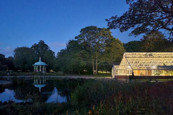 A green house lit up in Pearson Park