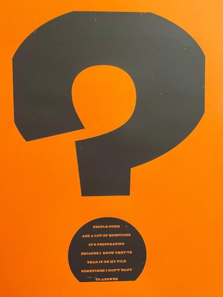 Black question mark on an orange background with the text 'People come. Ask a lot of questions. It's frustrating because I know that they've read it on my file.'